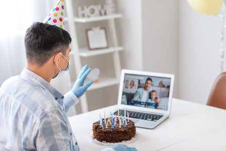 Asian man video chatting with friends on his Birthday at home. concept of epidemicの写真素材
