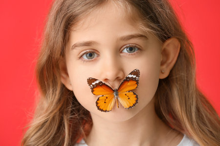 Cute little girl with butterfly on color backgroundの写真素材