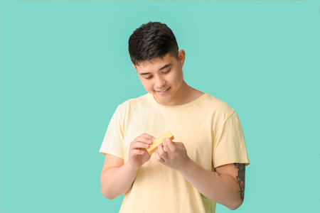 Asian man doing manicure on color backgroundの写真素材