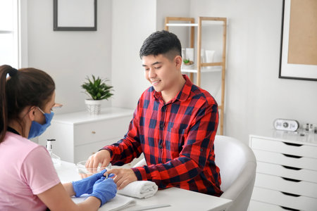 Manicure master working with male client in beauty salonの写真素材