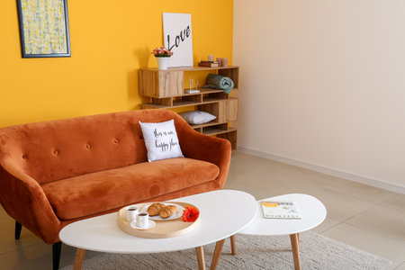 Stylish interior of living room with comfortable sofa and tablesの写真素材