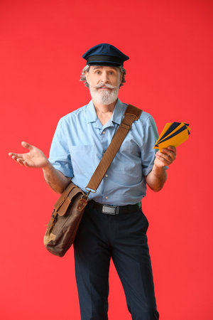 Handsome old postman on color backgroundの写真素材