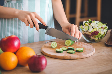 Beautiful young woman cooking in kitchen, closeupの写真素材