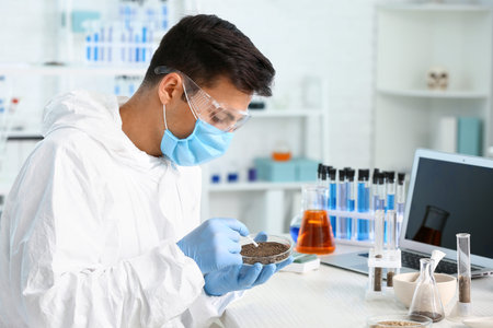 Scientist studying samples of soil in laboratory