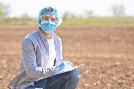 Scientist studying samples of soil in the fieldの写真素材