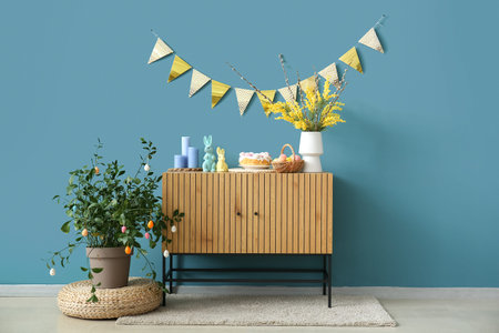 Easter decorations on wooden cabinet near blue wall