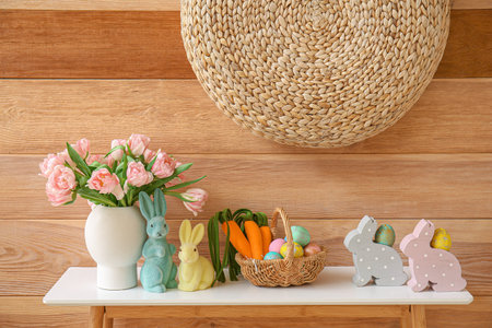 Vase with tulips, Easter eggs and decor on table in living room