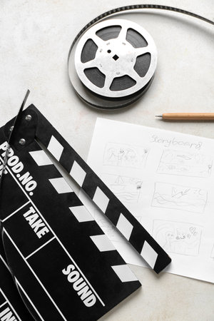 Movie clapper with storyboard and film reel on light backgroundの写真素材