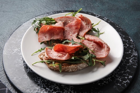 Plate of tasty bruschettas with ham on black backgroundの写真素材