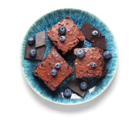 Plate with pieces of tasty chocolate brownie isolated on white backgroundの写真素材
