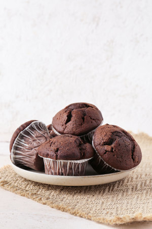 Plate with tasty chocolate cupcakes on tableの写真素材