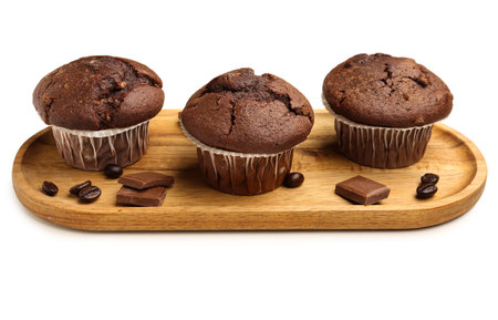 Wooden board with tasty chocolate cupcakes isolated on white backgroundの写真素材
