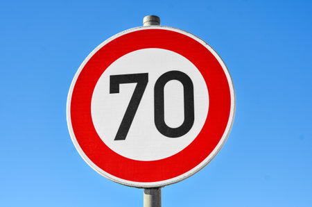 Speed limit 70 sign against blue sky, closeupの写真素材