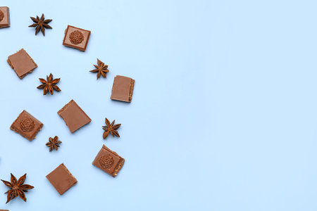 Composition with pieces of tasty chocolate and anise stars on color background