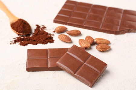 Tasty chocolate, almond nuts and coffee powder on light background, closeupの写真素材