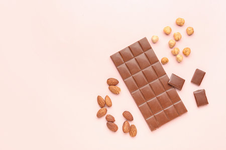 Composition with tasty chocolate and nuts on color backgroundの写真素材
