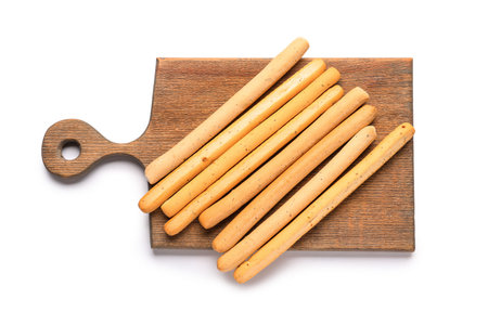 Wooden board with tasty Italian Grissini on white background