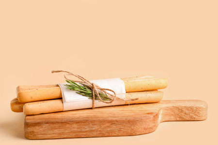 Wooden board with bunch of tasty Italian Grissini on yellow backgroundの写真素材