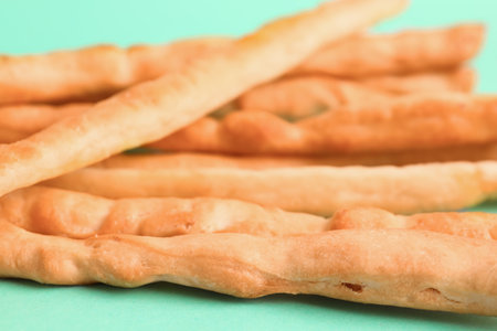 Tasty Italian Grissini on turquoise background, closeupの写真素材