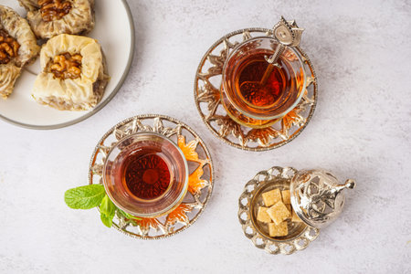 Glasses of tea and Turkish delight on white background