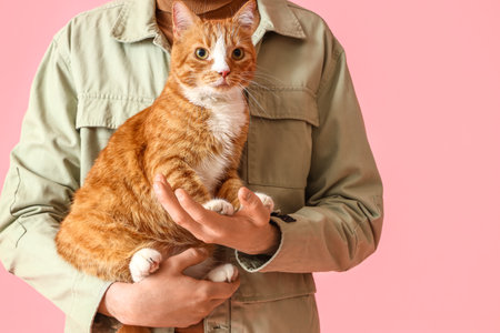 Man with funny red cat on pink backgroundの写真素材