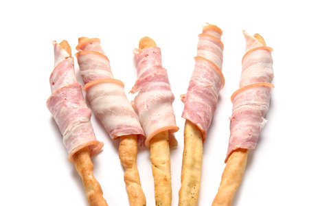 Tasty Italian Grissini with bacon on white background, closeupの写真素材