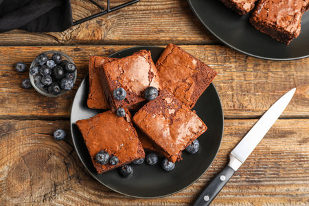 Plate with pieces of tasty chocolate brownie on wooden backgroundの写真素材
