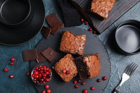Board with pieces of tasty chocolate brownie on black backgroundの写真素材
