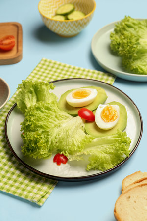 Plate with funny breakfast in shape of owl and ingredients on blue background, closeupの写真素材