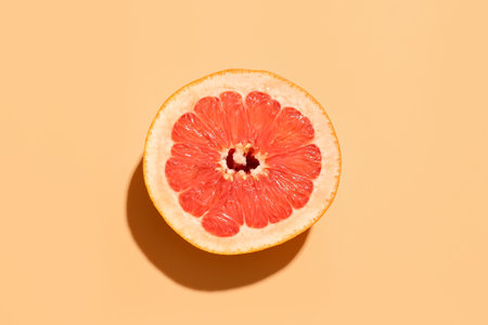 Half of juicy grapefruit on color backgroundの写真素材