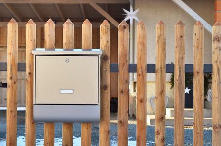 View of metal mailbox on wooden fenceの写真素材