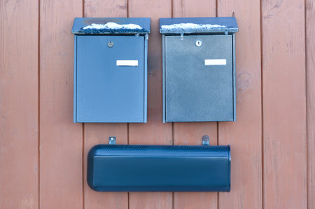 View of metal mailboxes on wooden fenceの写真素材