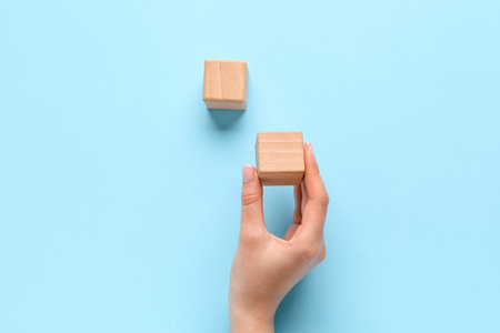 Woman with wooden cubes on blue backgroundの写真素材