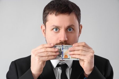 Businessman with bribe on gray background, closeupの写真素材