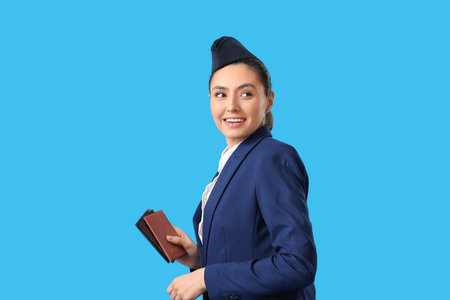 Beautiful stewardess with passports on blue backgroundの写真素材