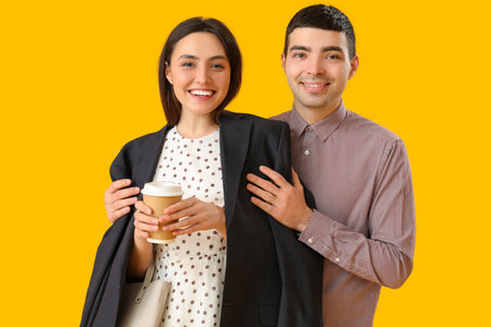 Lovely young couple on yellow backgroundの写真素材