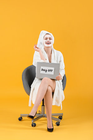 Woman after shower with laptop on color background. concept of the weekendの写真素材