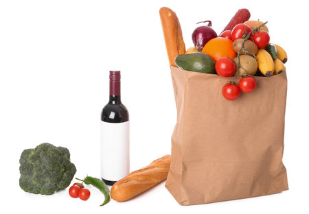 Paper bag with vegetables, fruits and wine bottle on white backgroundの写真素材