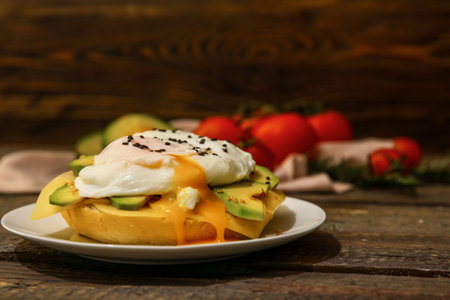 Plate with tasty egg Benedict on wooden background, closeupの写真素材