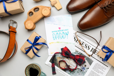 Composition with greeting card, male accessories, toys and gifts for Father's Day celebration on white backgroundの写真素材