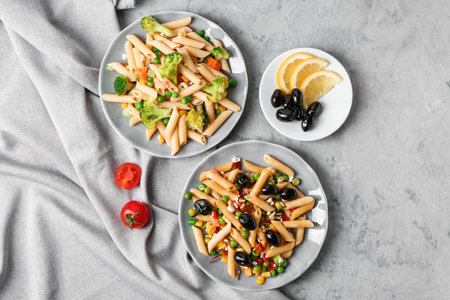 Plates with tasty pasta salad on grunge backgroundの写真素材