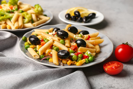 Plates with tasty pasta salad on tableの写真素材