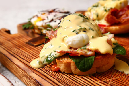 Board with delicious egg Benedict, closeupの写真素材