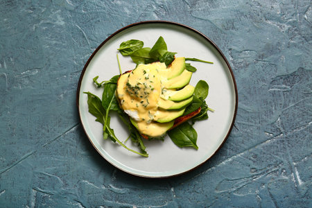 Plate with tasty egg Benedict on gray grunge tableの写真素材