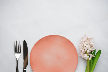 Clean plate, cutlery and beautiful hyacinth flower on white backgroundの写真素材