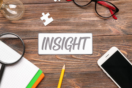 Word INSIGHT with magnifier, notebook and mobile phone on wooden backgroundの写真素材