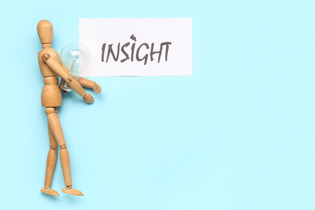 Paper with word INSIGHT, wooden mannequin and light bulb on blue backgroundの写真素材
