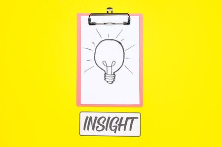 Clipboard with drawn light bulb and word INSIGHT on yellow backgroundの素材 [FY310200931135]