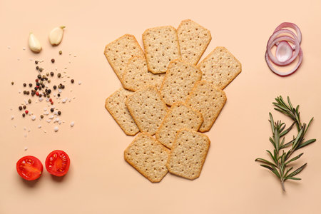 Tasty crackers, spices, vegetables and rosemary on beige backgroundの写真素材