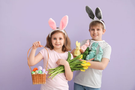 Little children in bunny ears with Easter eggs, toy rabbits and tulips on lilac background